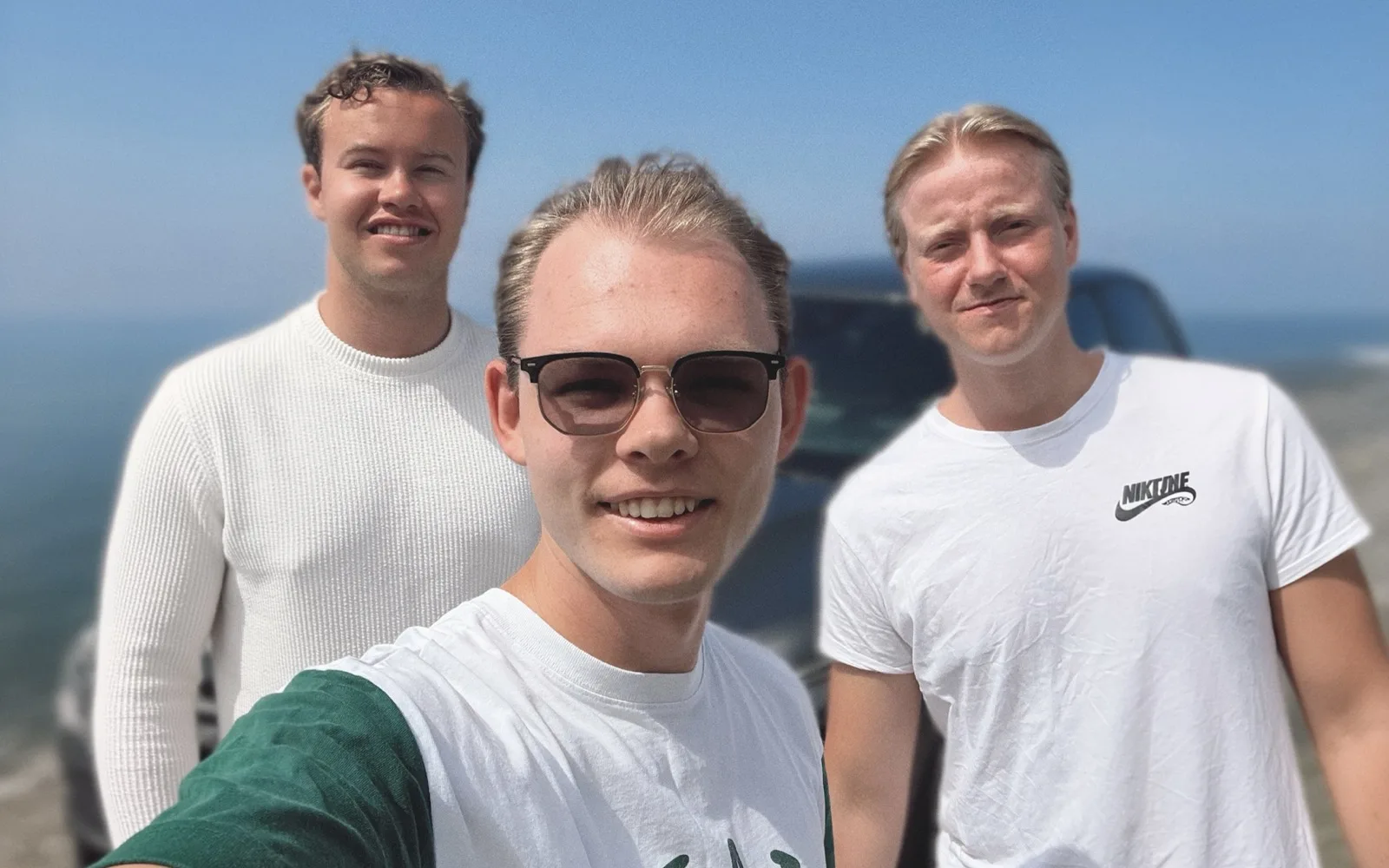 Three members of the Enthemed team outdoors on a clear day by the coast.